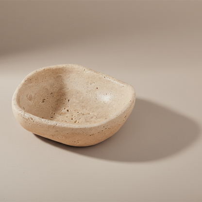 Beige travertine bowl on a beige background
