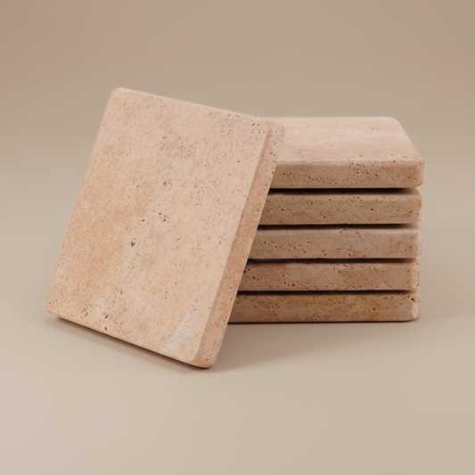 Set of square travertine stone coasters on a beige background