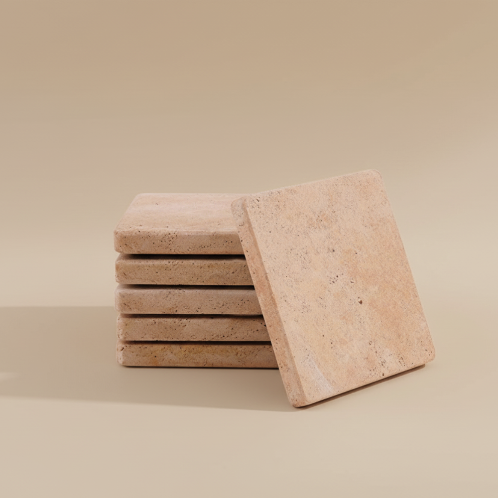 Stack of travertine stone coasters on a beige background