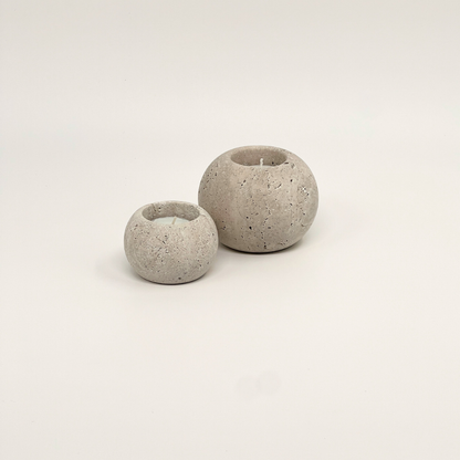 Two travertine candle holders on a light beige background