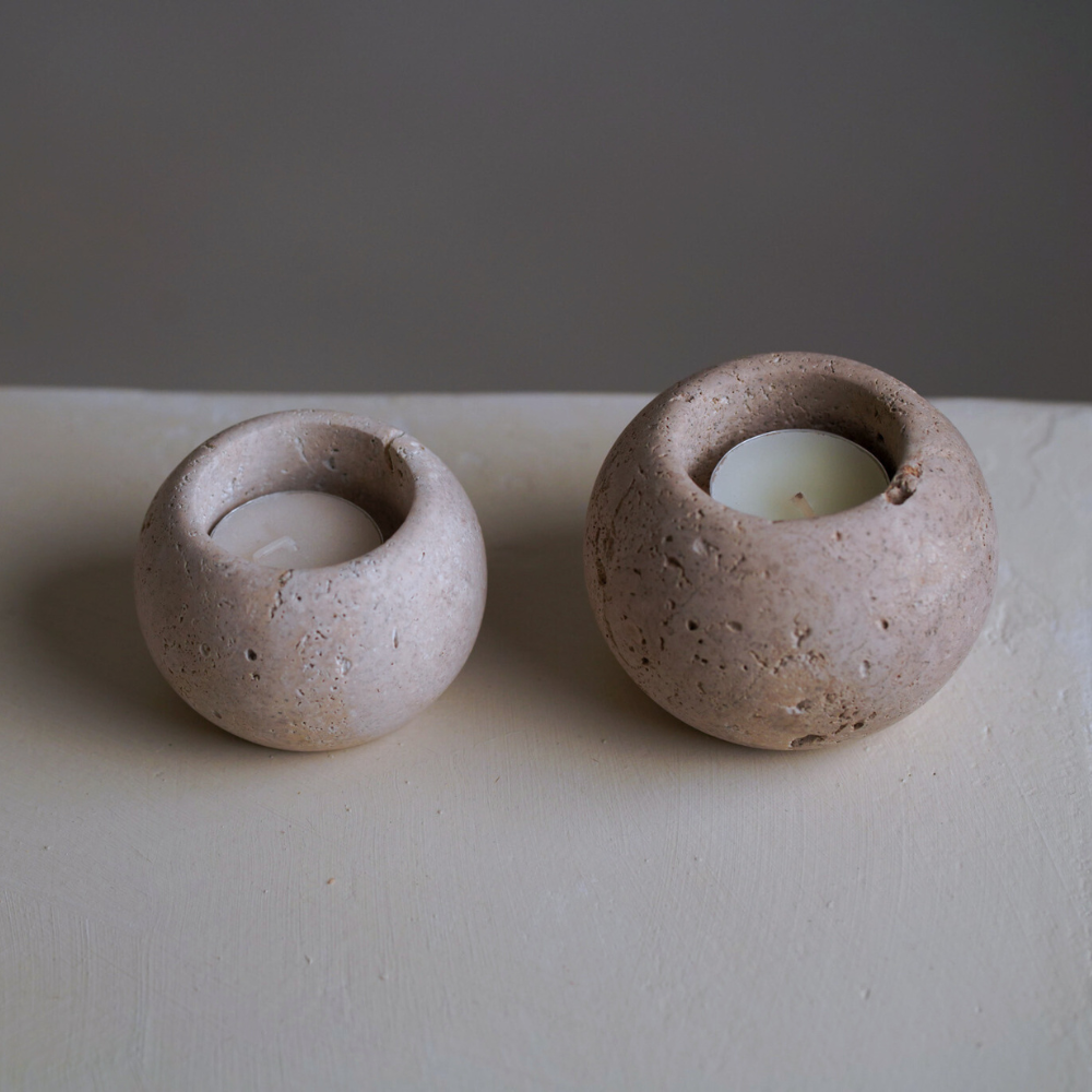 Two travertine candles on a stone bench