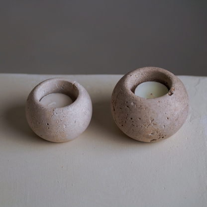 Two travertine candles on a stone bench