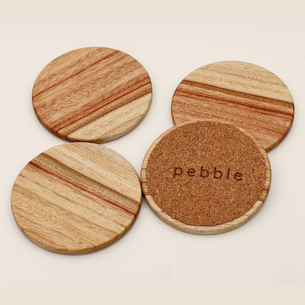 Four wooden coasters with cork bottom on a light background