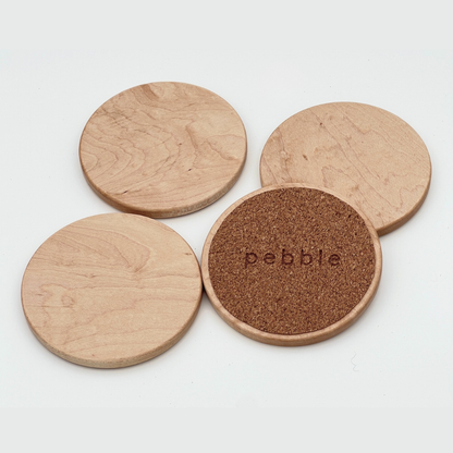 Four wooden coasters with cork bottom on a white background