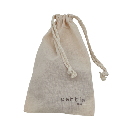 Calico drawstring bag with 'pebble studio' branding on a white background