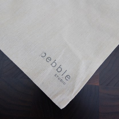 Pebble Studio logo on a calico bag.