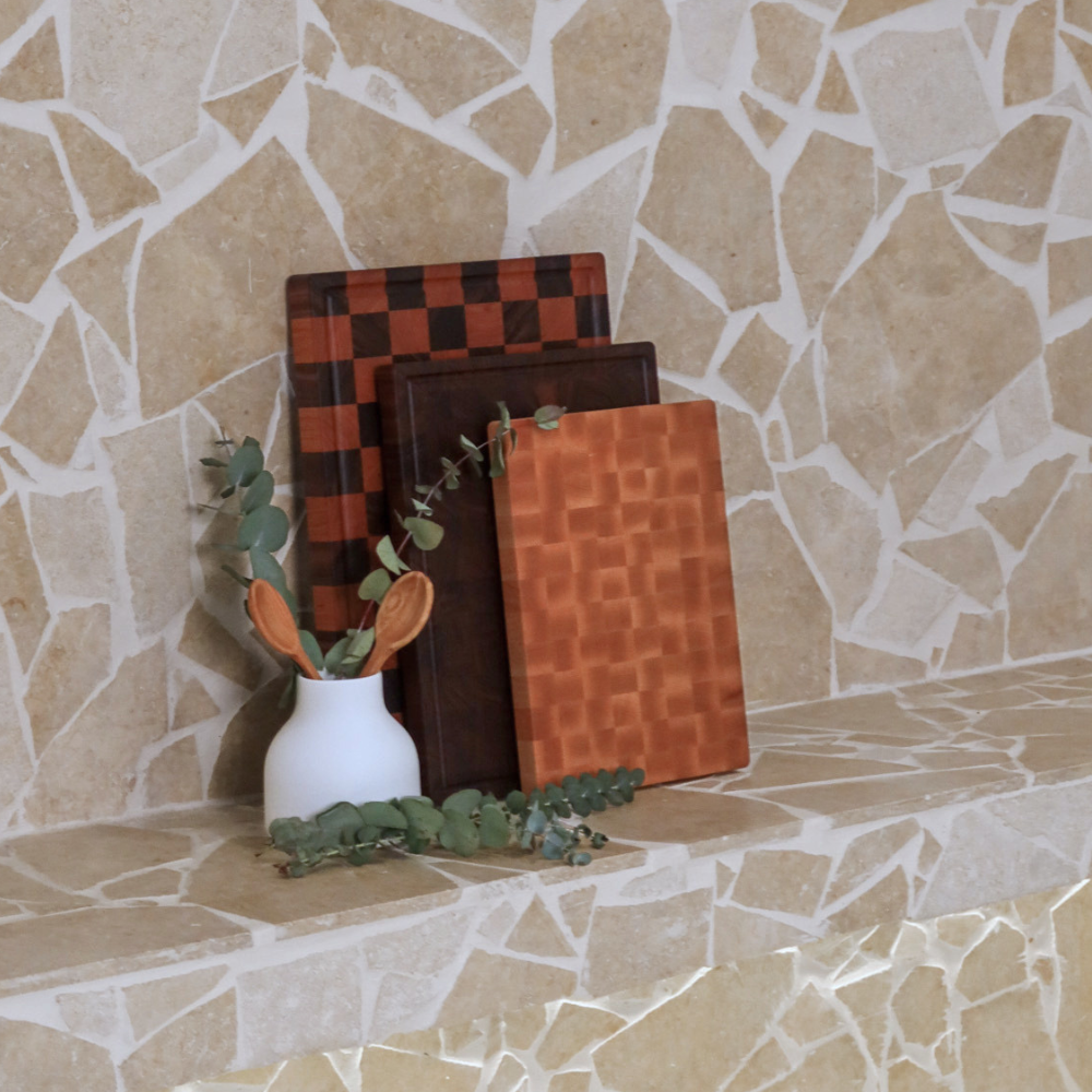 Set of end-grain chopping boards made from different timbers on a stone surface