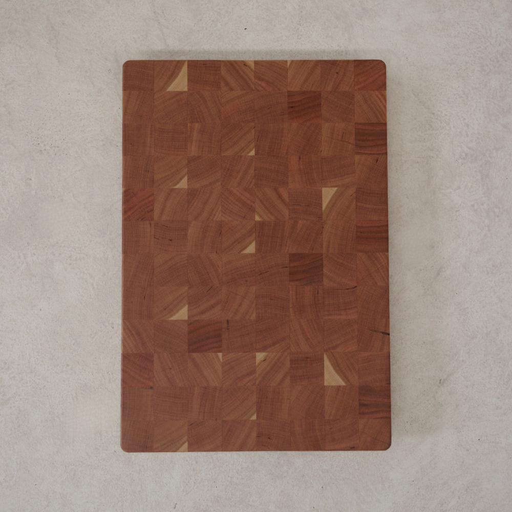 Wooden chopping board with a checkered pattern on a light grey surface