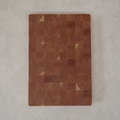 Wooden chopping board with a checkered pattern on a light grey surface