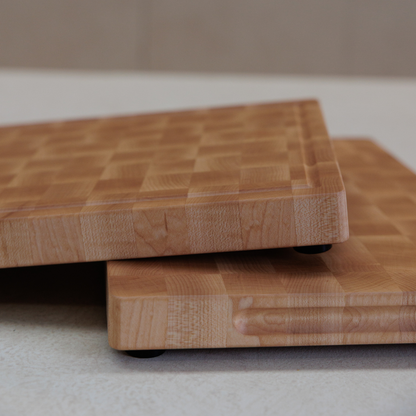 Two wooden cutting boards stacked on a neutral background