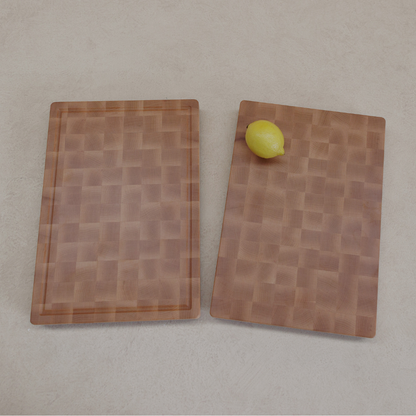 Two wooden cutting boards with a lemon on a grey background