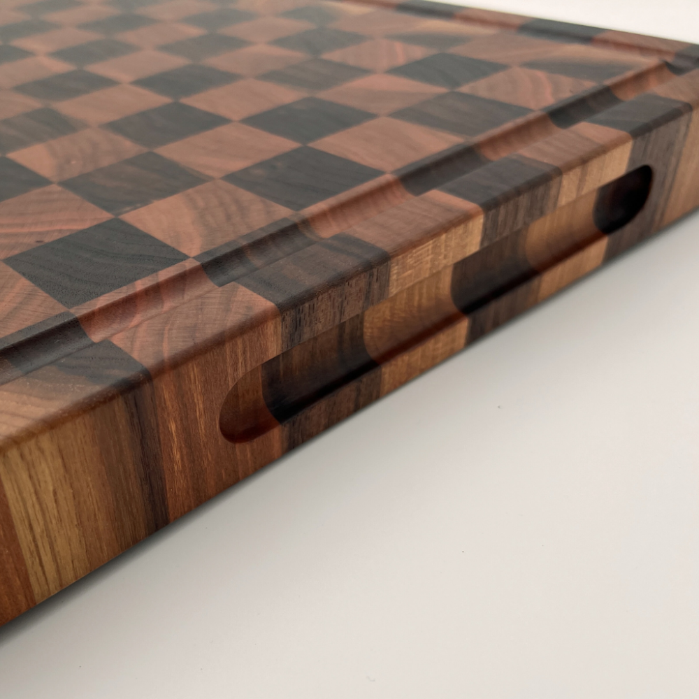 Wooden chopping board with checkered pattern on a light grey background