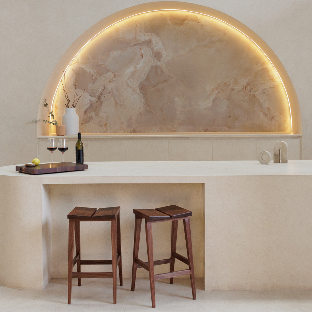 Modern kitchen with chopping board,  wine bottle and glasses on a benchtop with bar stools.