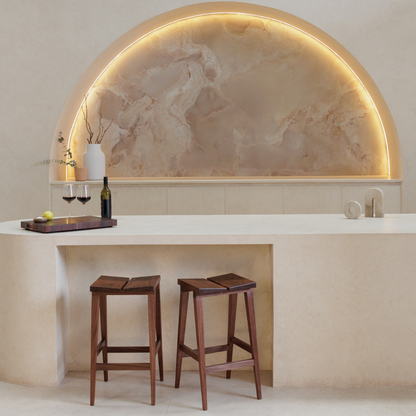 Modern kitchen with chopping board,  wine bottle and glasses on a benchtop with bar stools.