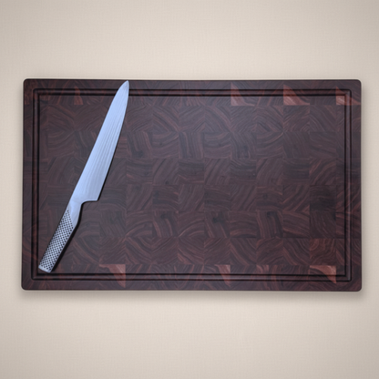 Walnut end-grain chopping board with a knife on a beige background