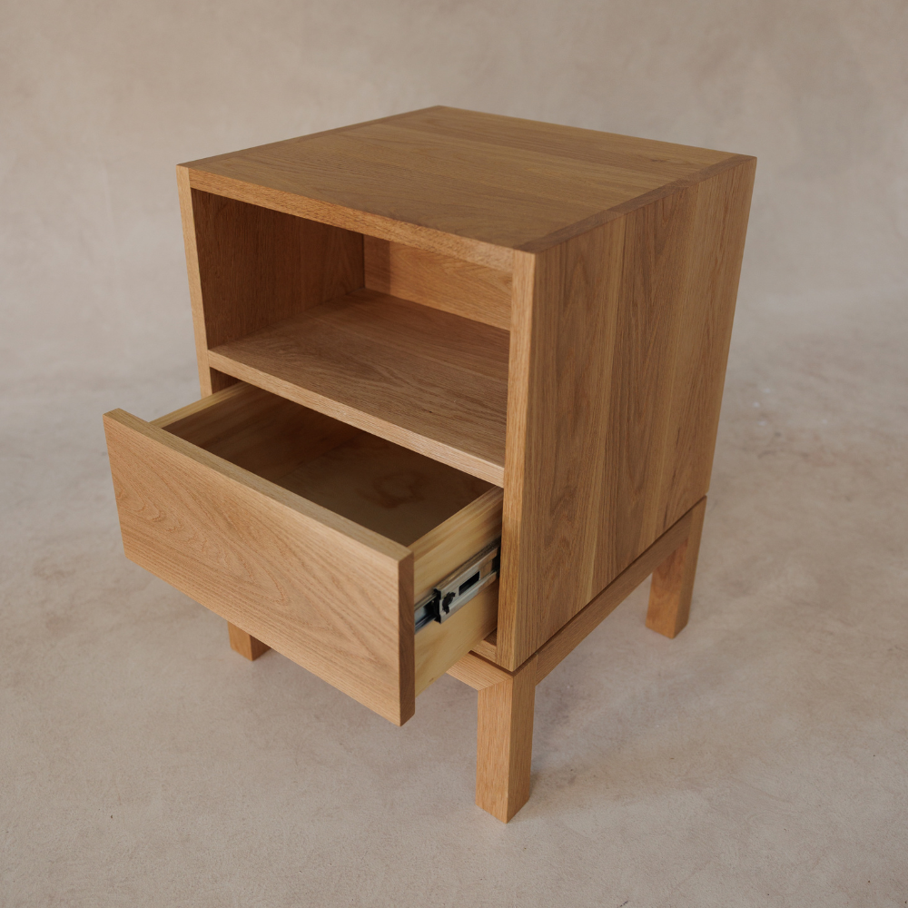 Wooden bedside table with a drawer on a beige background