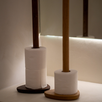 Two toilet roll holders with rolls of toilet paper on a neutral background