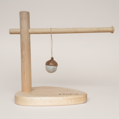 Hand turned walnut and marbled beige felt acorn ornament with jute loop, hanging from a wooden stand. Australian handmade natural Christmas decoration