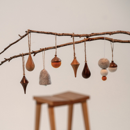 Handmade Christmas ornaments on a branch, for slow holiday styling