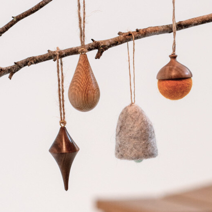 Decorative hanging ornaments on a branch with a neutral background