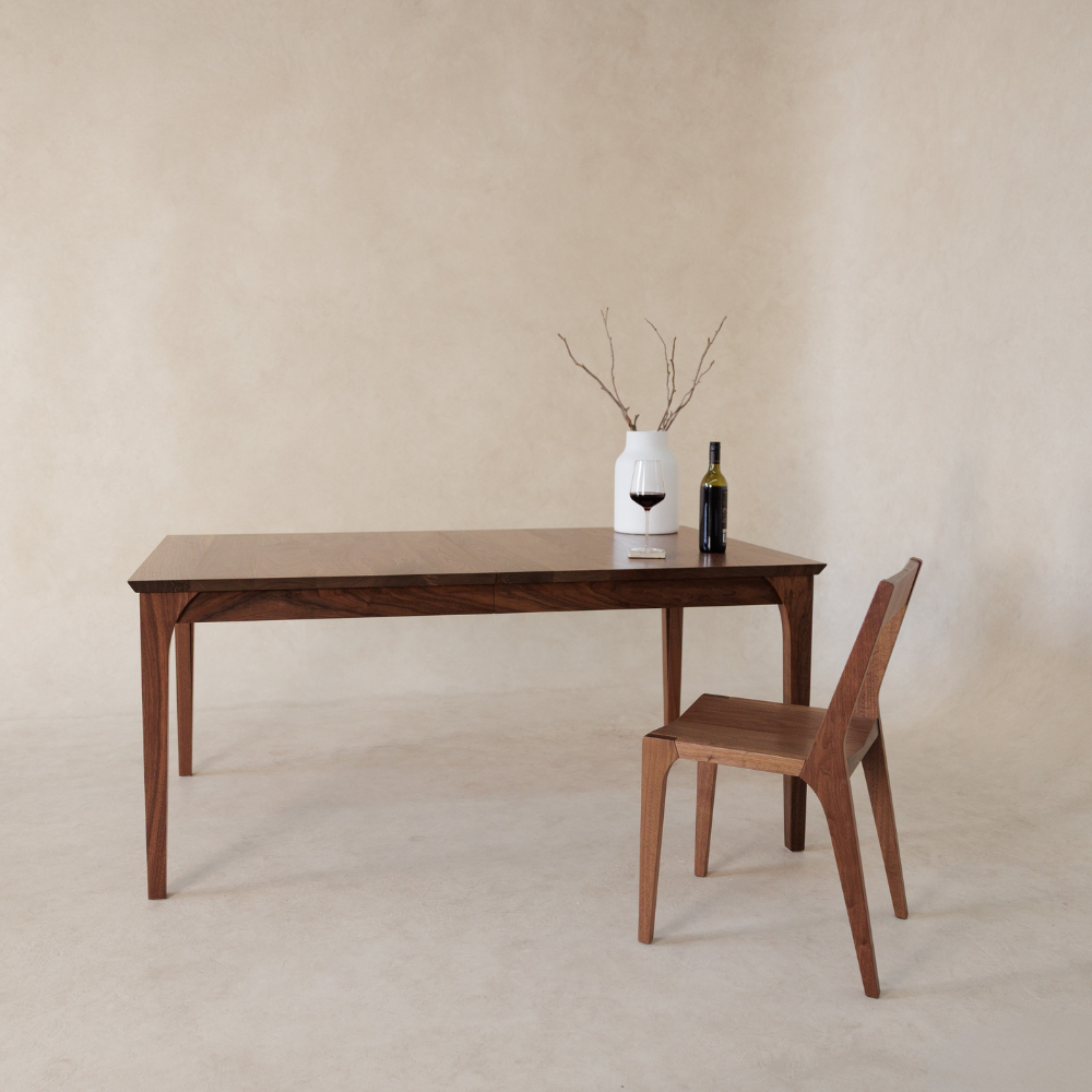 Wooden dining table with a chair against a beige wall