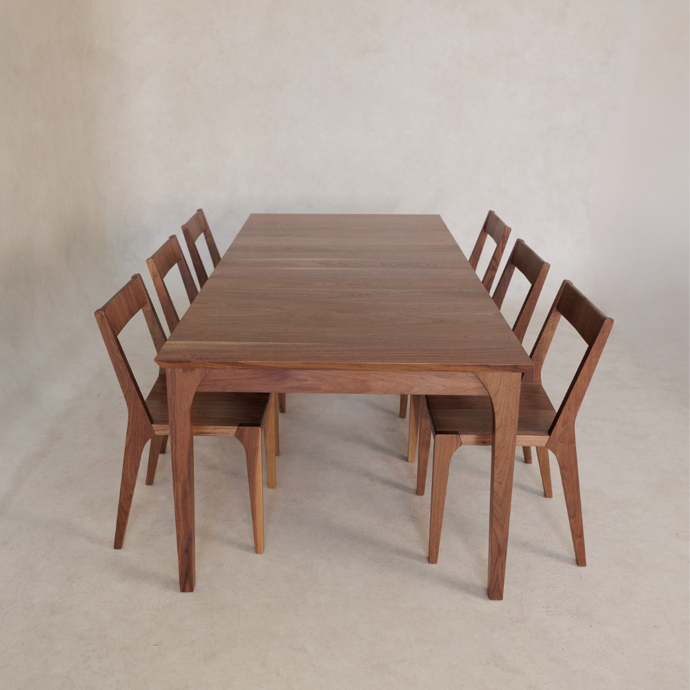 Wooden dining table with six chairs on a plain background