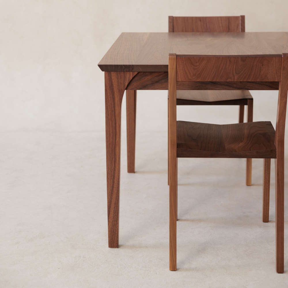 Wooden dining table with chairs on a light background