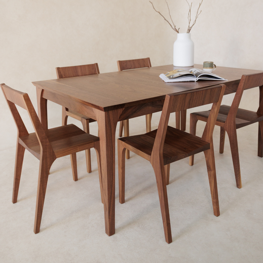 Wooden dining table with six chairs in a minimalistic setting