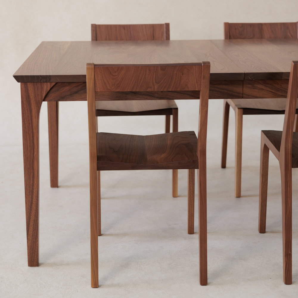 Wooden dining table with chairs on a plain background