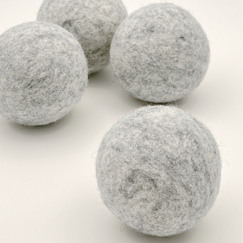 Four grey felt balls on a white background