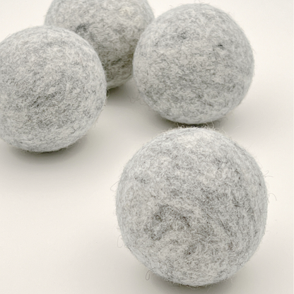 Four grey felt balls on a white background