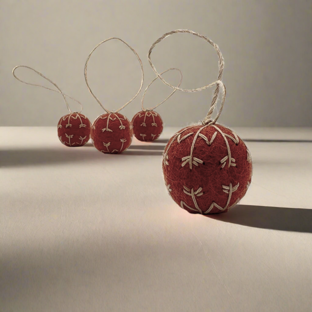 Red felt ball ornaments with string on a light surface