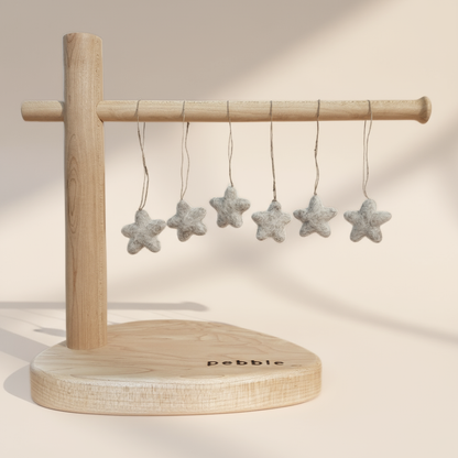 Six tiny felt star decorations hanging from a wooden stand