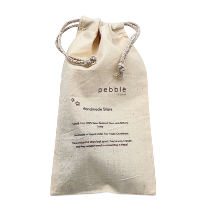 Beige drawstring bag with 'pebble studio' branding on a white background