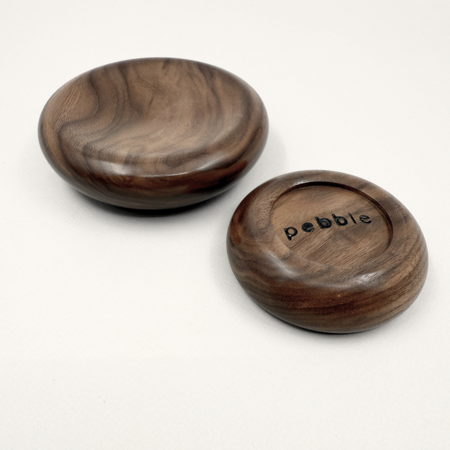 Two wooden bowls with 'Pebble' branding on a white background