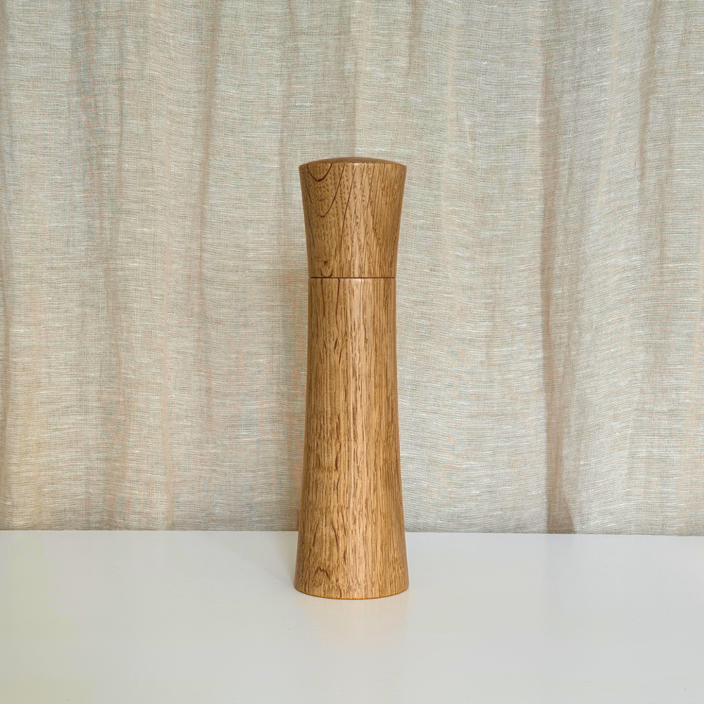 Large Pebble Studio Salt & Pepper Mill in American Oak. Minimalist design on a neutral background