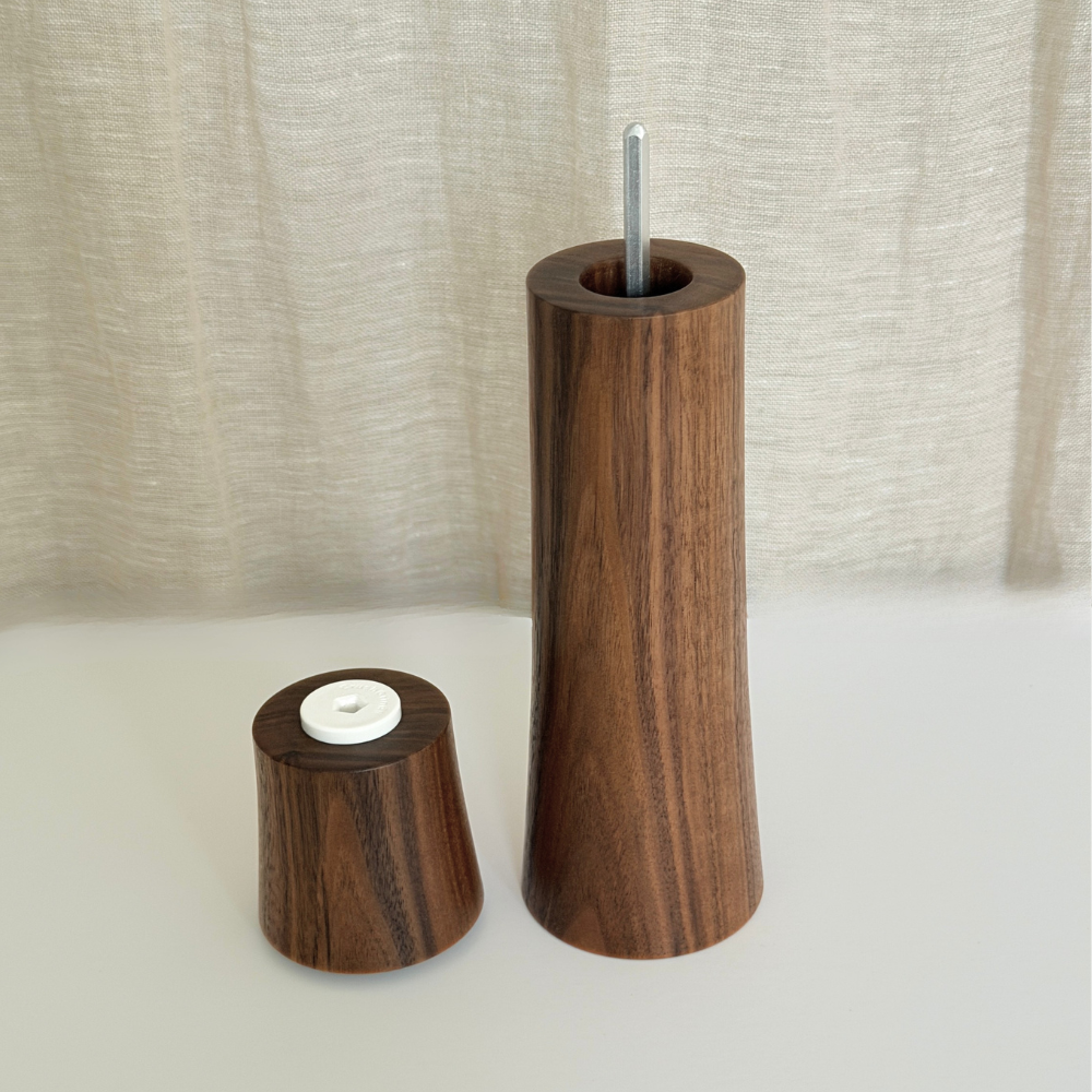 Pebble Studio handcrafted Walnut salt & pepper mill in Large size with top sitting next to the base