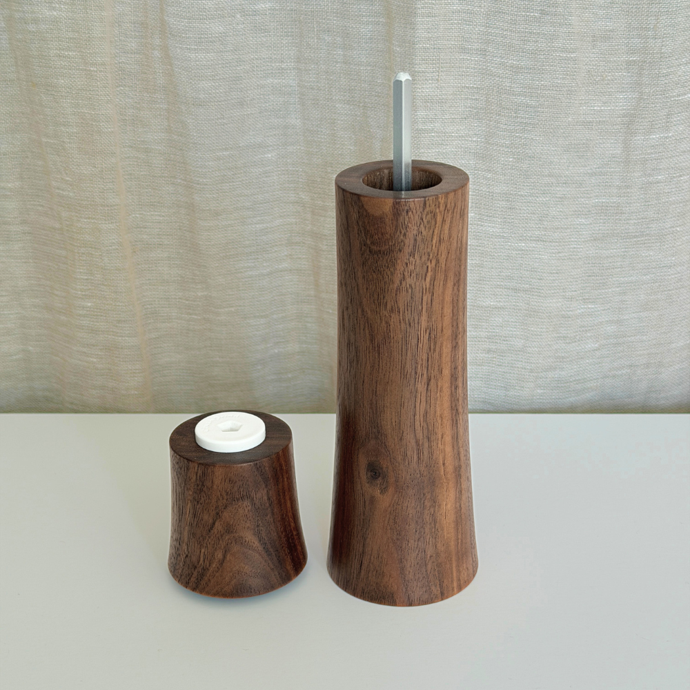 Pebble Studio handcrafted Walnut salt & pepper mill in Medium size with top sitting next to the base