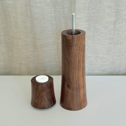 Pebble Studio handcrafted Walnut salt & pepper mill in Medium size with top sitting next to the base