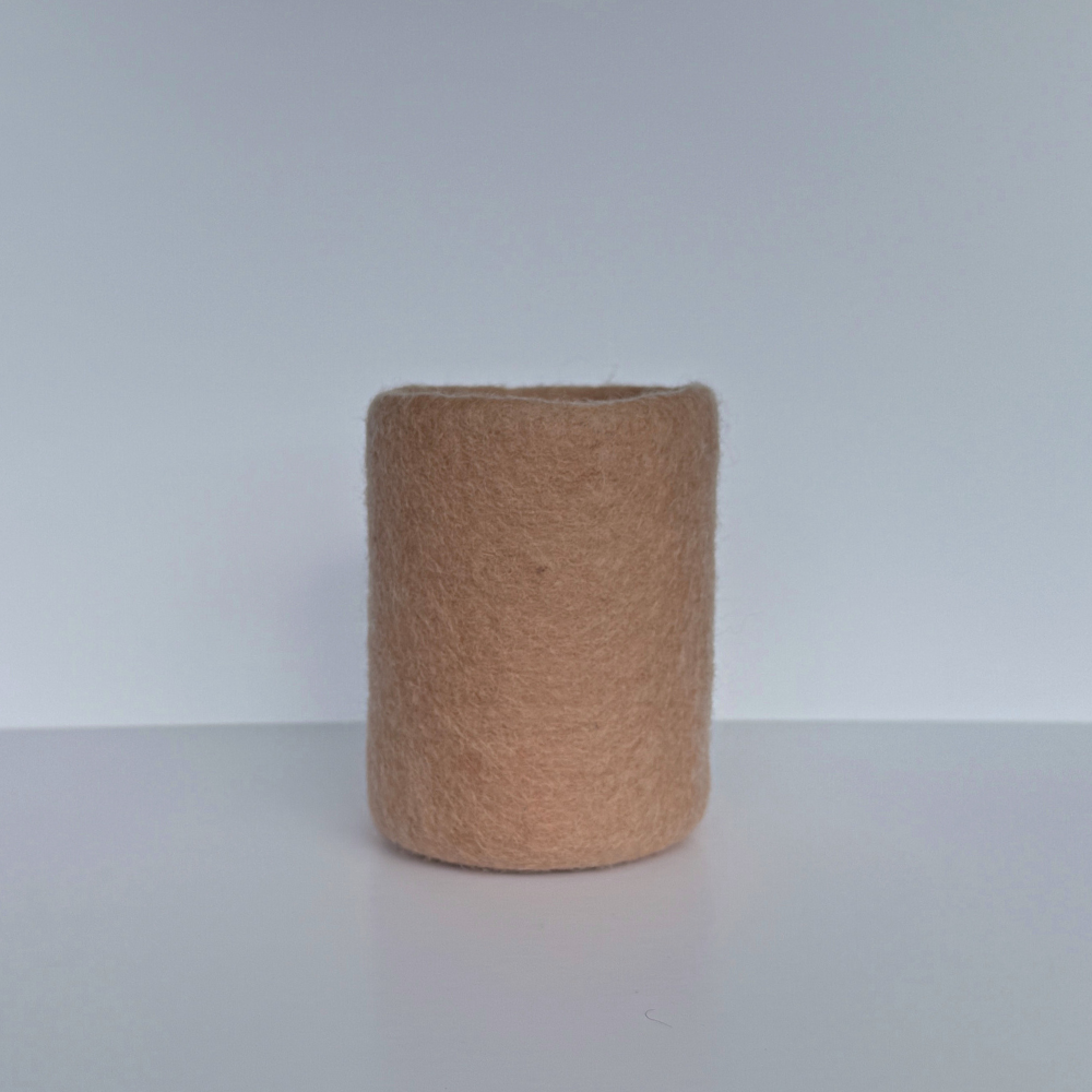 soft blush handcrafted wool storage or vase on light background