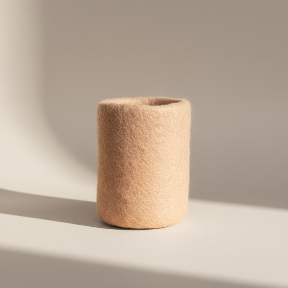 soft blush handcrafted wool storage or vase on light background