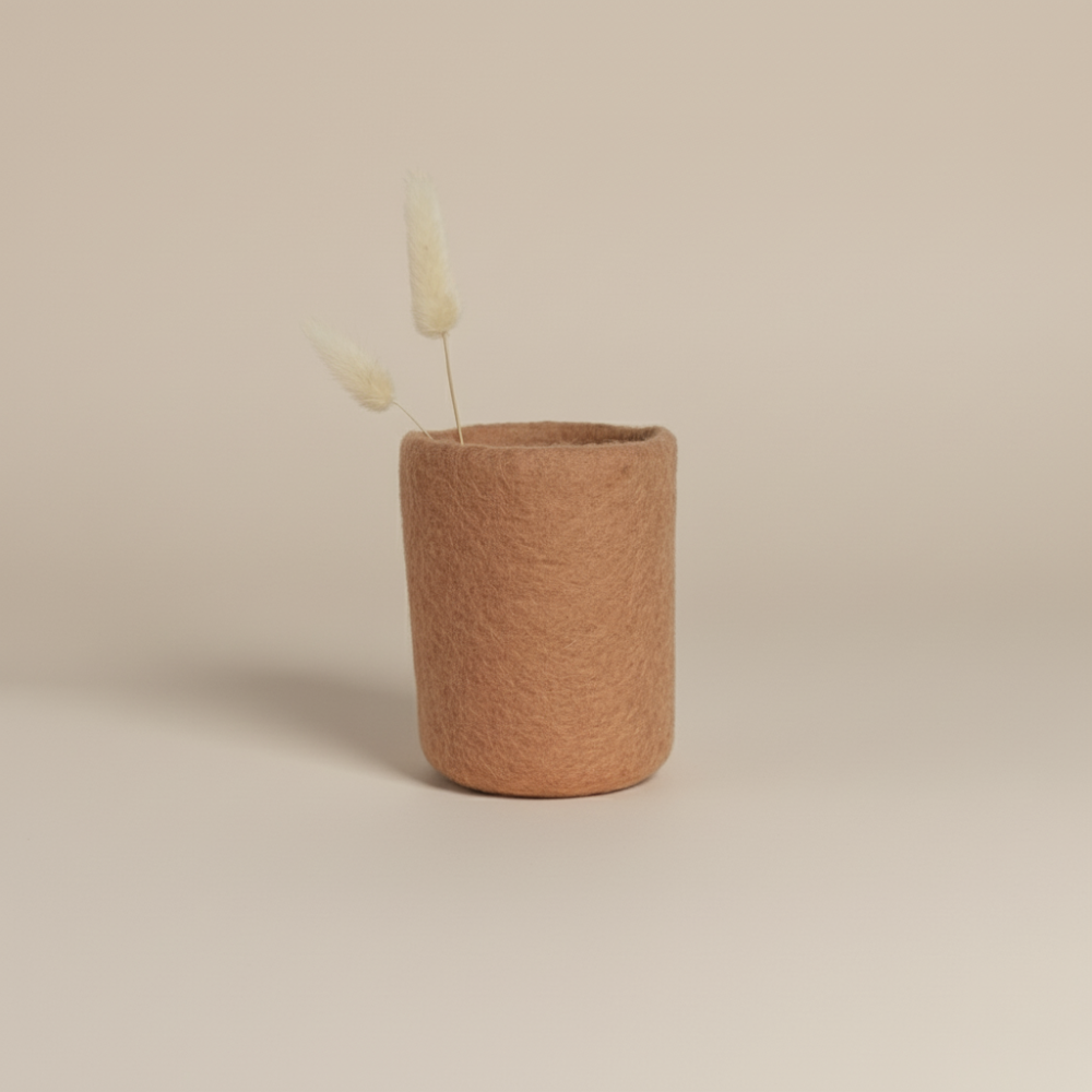 soft blush handcrafted wool storage or vase on light background