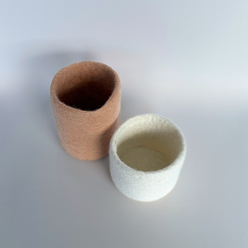 soft blush and snow handcrafted wool storage or vase on light background