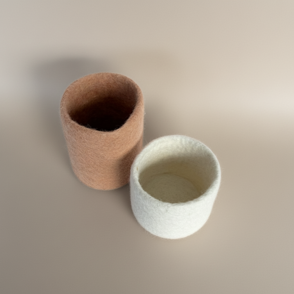 soft blush and snow handcrafted wool storage or vases on light background