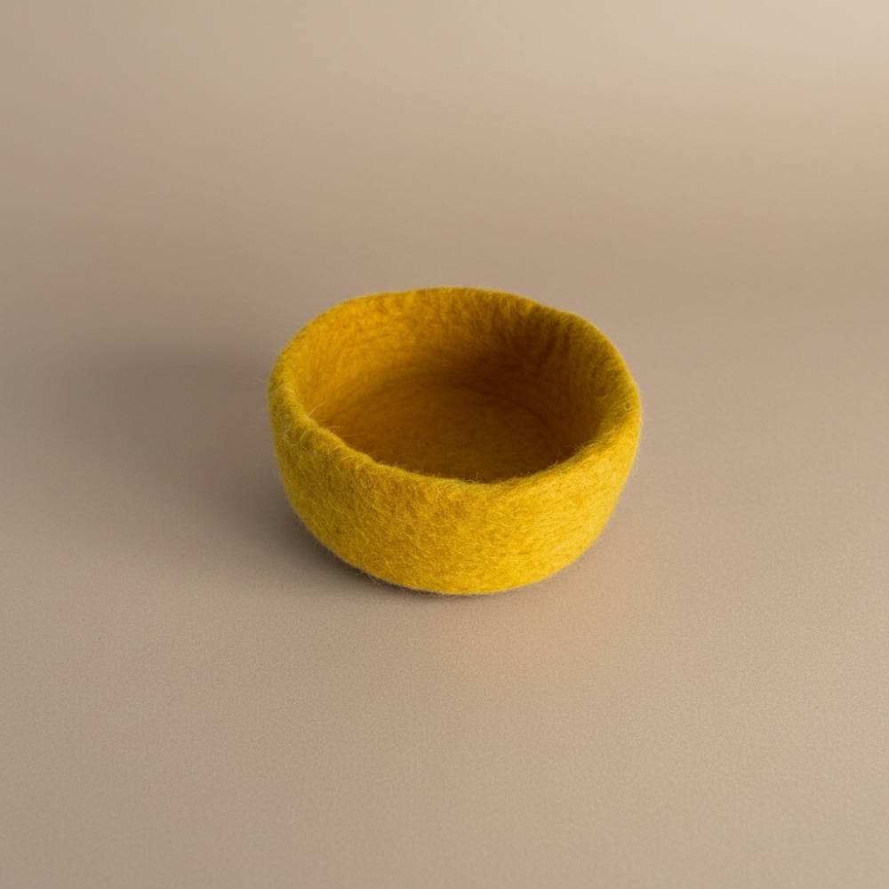 Yellow felted bowl on a beige background