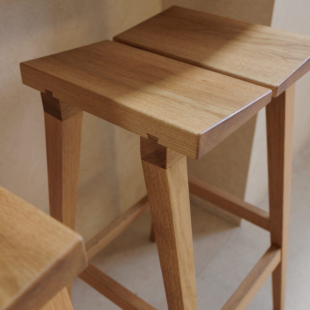 Two wooden stools with a neutral background