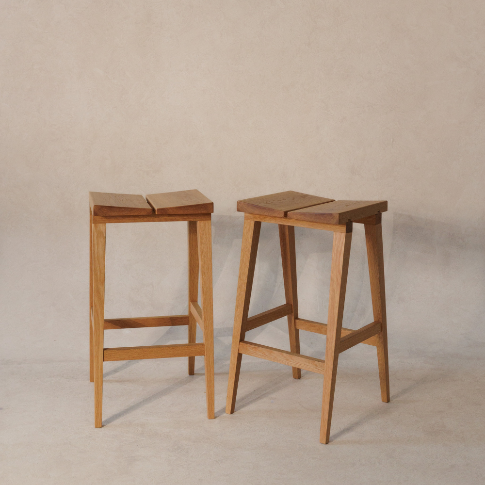 Two wooden bar stools on a plain background