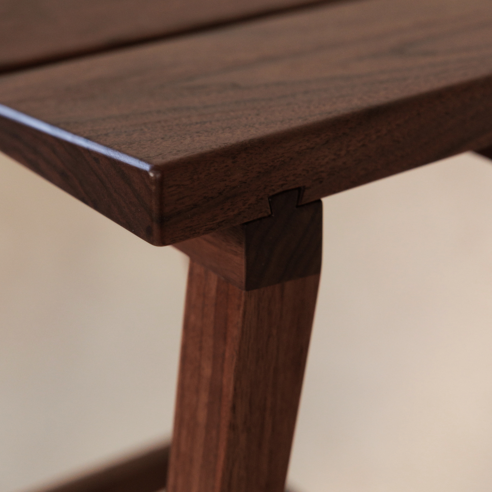 Close-up of a wooden stool leg on a beige background