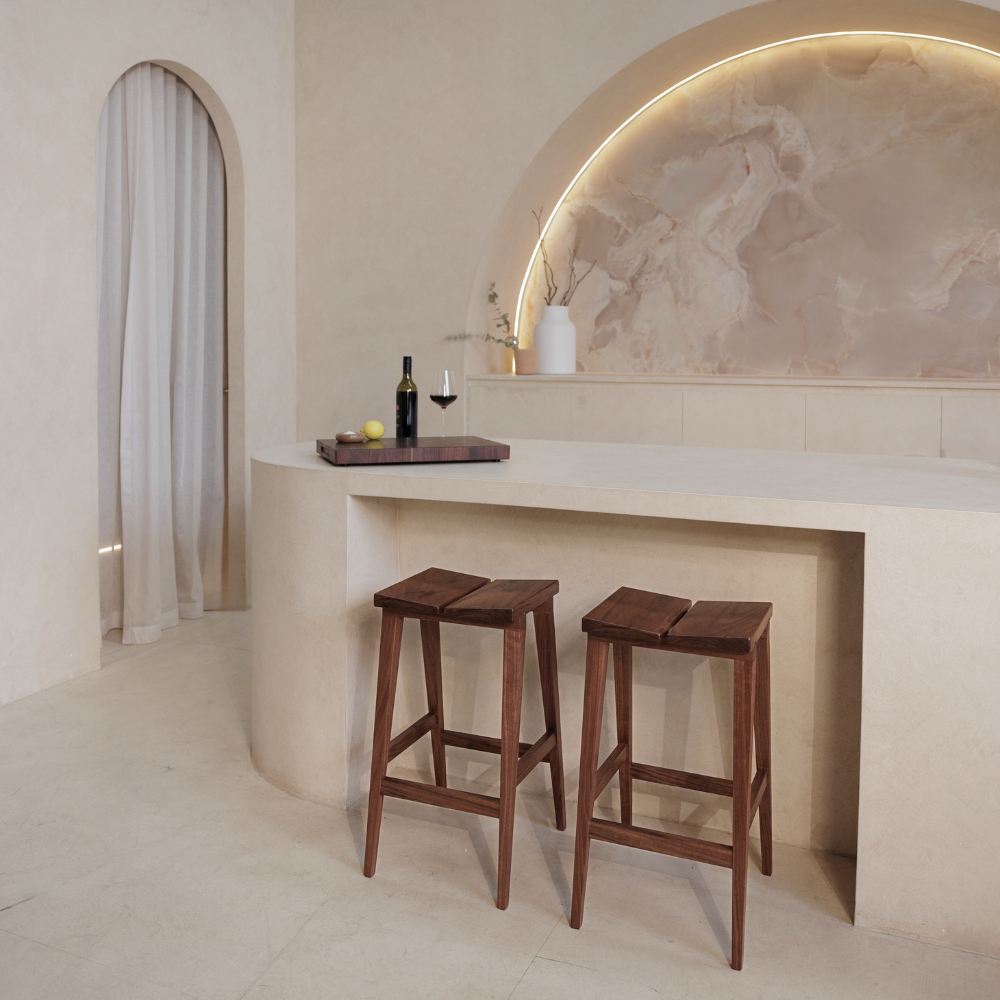 Modern kitchen with wooden stools and a marble backsplash