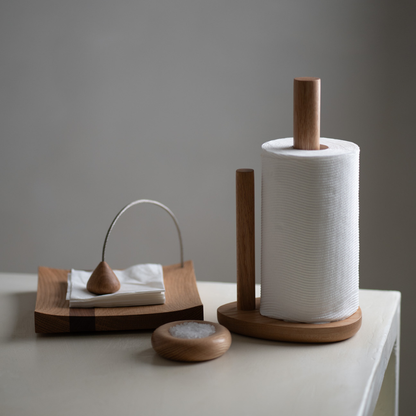 Wooden paper towel holder with a roll of paper towels on a neutral background